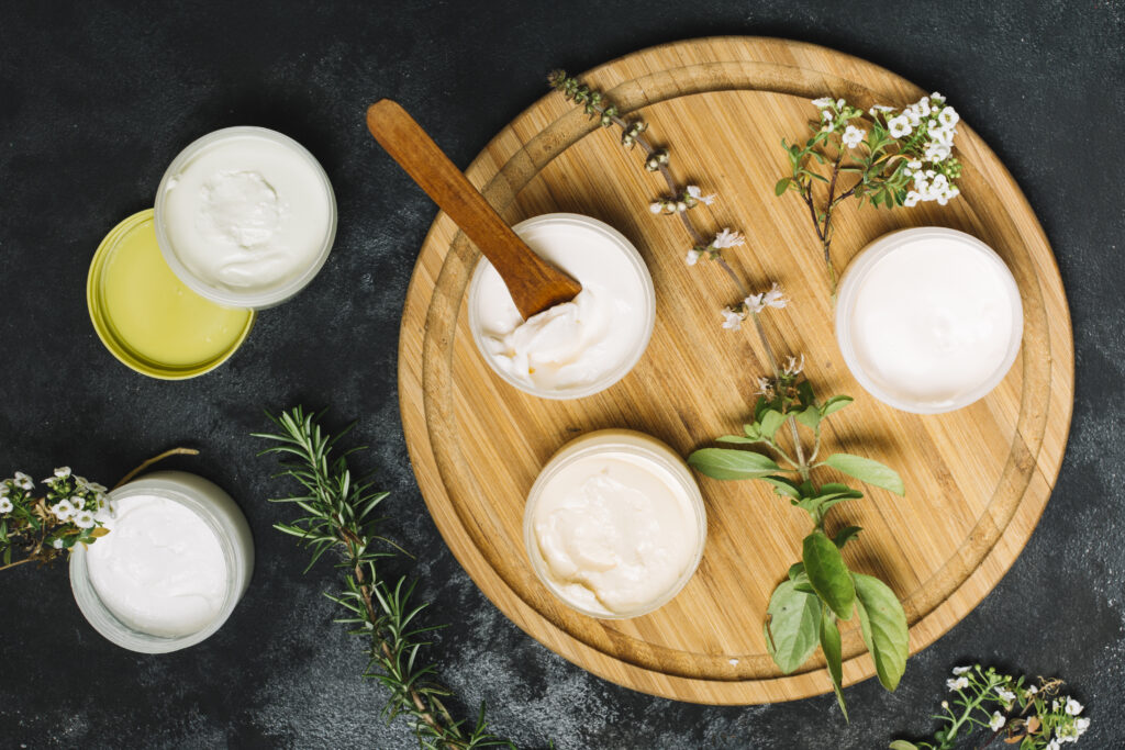 A jar of homemade whipped body butter with a smooth, creamy texture, surrounded by natural ingredients like shea butter and essential oils.